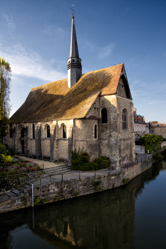 A church sits on the river in Sens.